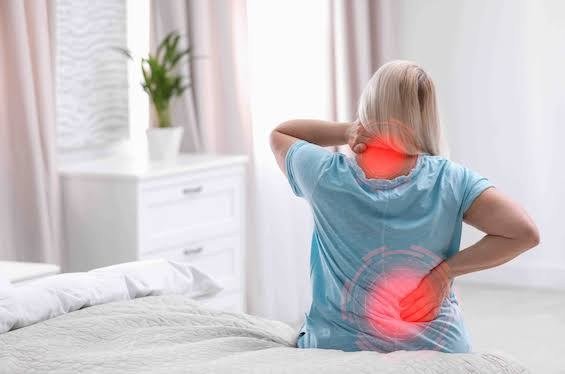 Adult experiencing neck and lower-back discomfort during a home routine